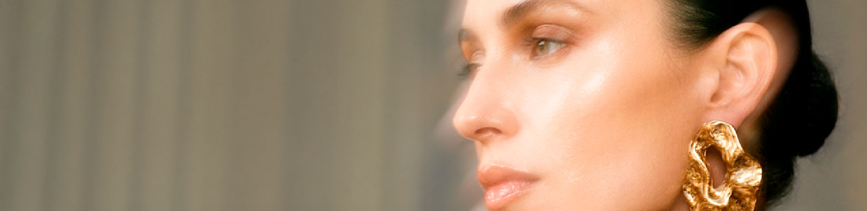Retrato editorial de una modelo con pendiente dorado